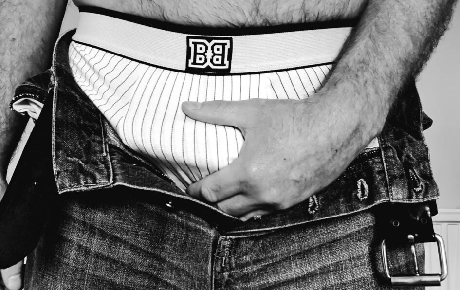 Man holding his bulge with his jeans open